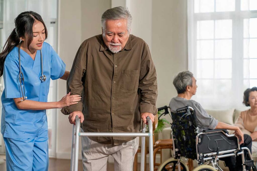 Older resident speaking with a caregiver in a bright assisted living common room