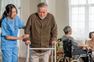 Older resident speaking with a caregiver in a bright assisted living common room