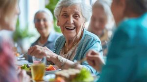 Caregiver reviews a care plan with an older resident at a table in an assisted living apartment.